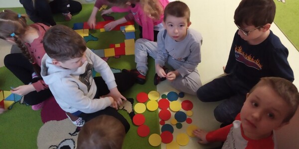 Dzieci rozkładające koła na dywanie