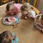 Dzieci obserwują efekt eksperymentu przedstawiającego jesienne drzewo z kolorową pianą na aluminiowej tacce..jpg