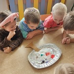 Dzieci obserwują kolorową reakcję chemiczną na talerzu z pianą i barwnikami_ tworzącą jesienne drzewo..jpg