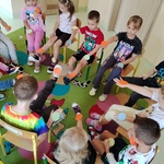Dzieci siedzą na krzesełkach w kole. Na hasło; koło pomarańczowe_ podnoszą odpowiednią kończynę..jpg