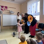 Dzieci wręczają upominek podczas uroczystości z okazji Dnia Edukacji Narodowej w przedszkolu.jpeg