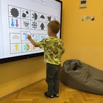 Chłopiec korzysta z interaktywnej gry edukacyjnej na ekranie dotykowym.JPG