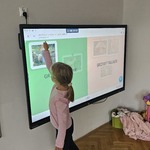 Dziewczynka uczestniczy w interaktywnym zadaniu i wskazuje ilustrację grzyba w części dotyczącej grzybów jadalnych.jpg